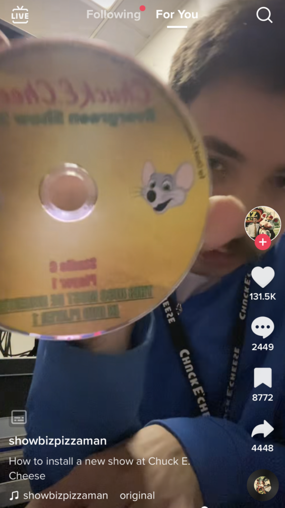 man holding cd with backwards text on it