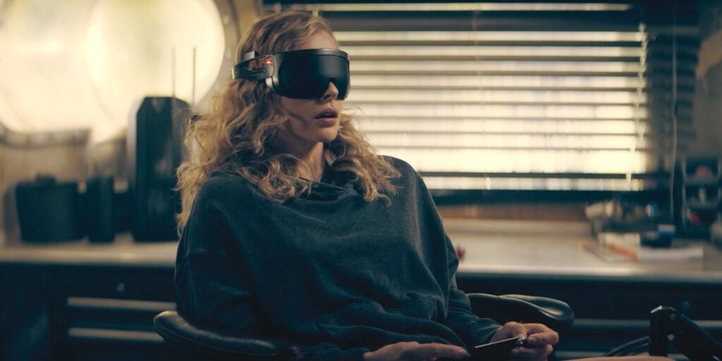 Chloë Grace Moretz as Flynne Fisher using a traditional VR headset with display and a handheld controller. As seen in The Peripheral (2022)